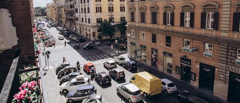 A street view with parked cars, buildings, and a clear sky.