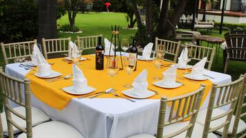 A round table set for a meal with white napkins, silverware, and wine glasses.