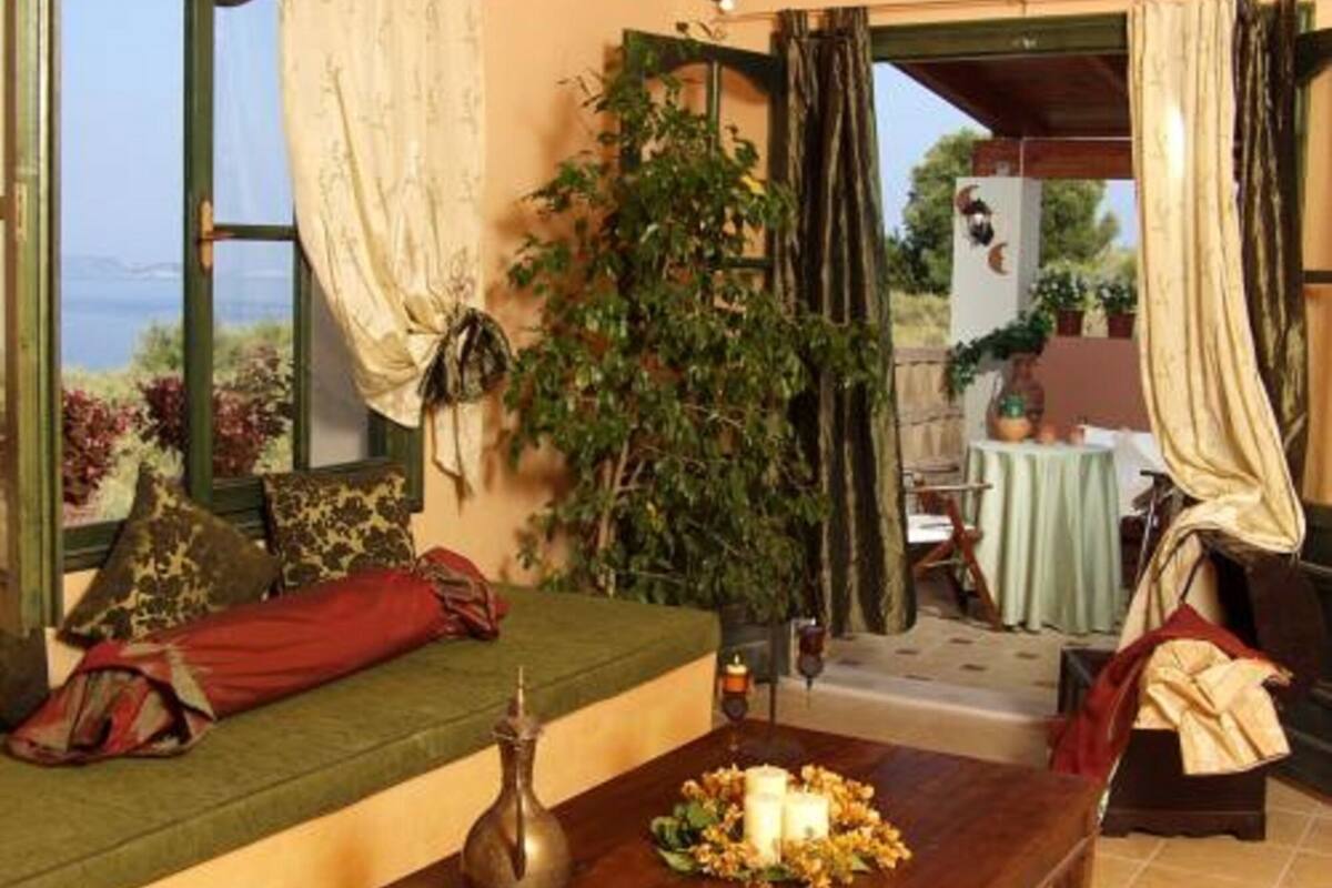 A cozy room with a sofa, a table with candles, and a view of the outdoors.