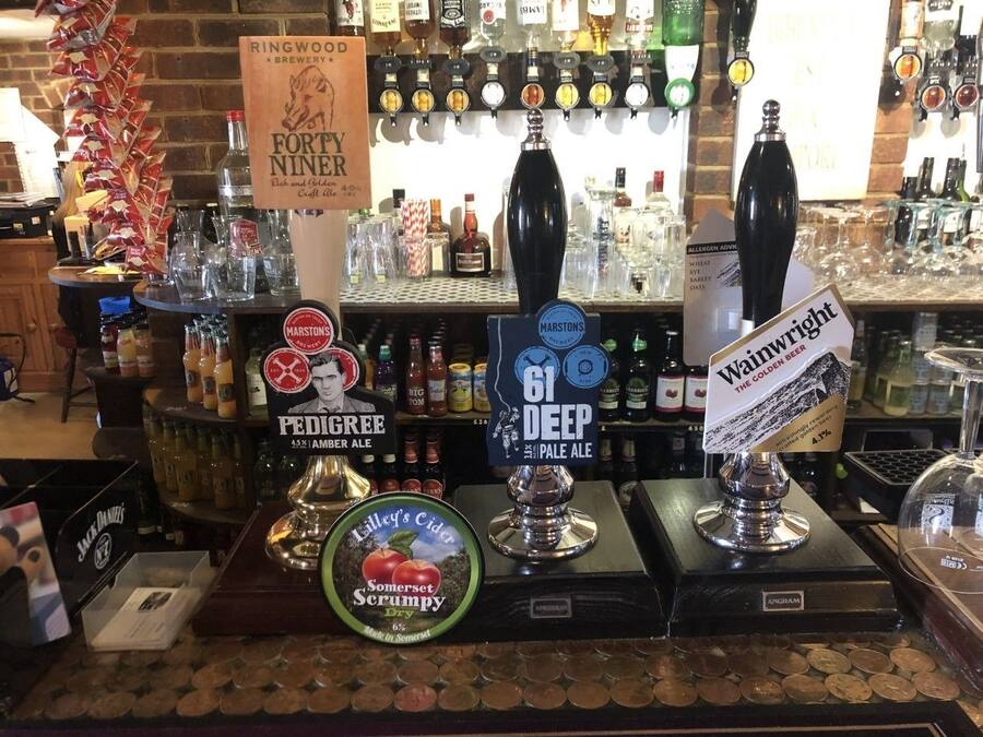 A bar area with multiple taps labeled with different beer brands and types.