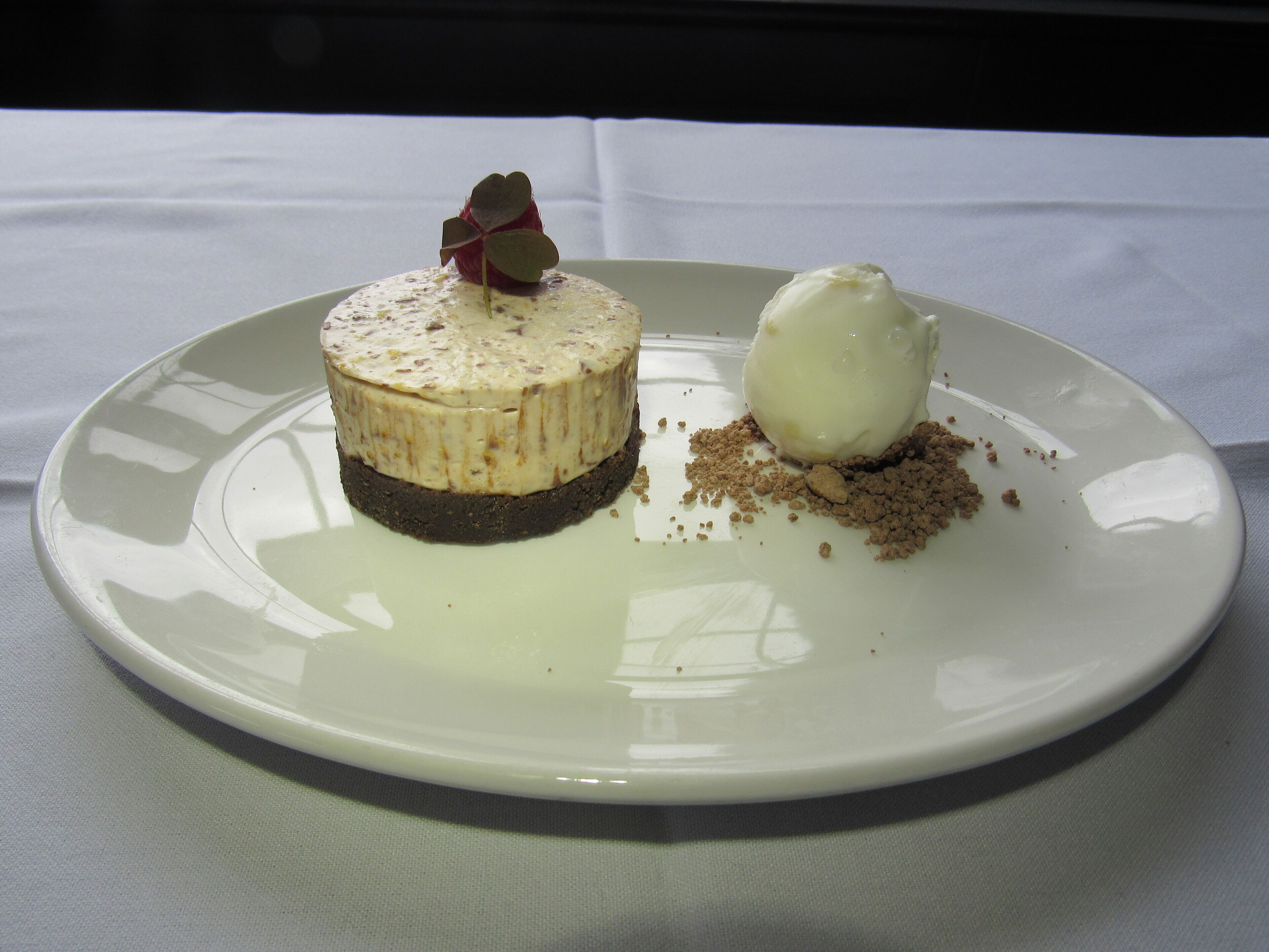 A dessert on a white plate with a white tablecloth.
