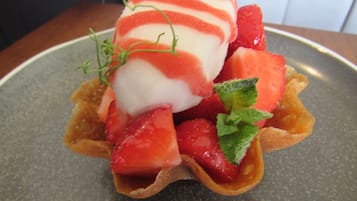 A dessert with strawberries and a scoop of ice cream on a plate.