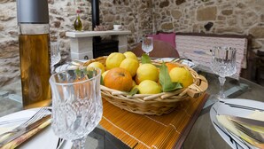 A dining table set with a basket of lemons and oranges, a thermos, and crystal glasses. - Mylos (Kissamos)