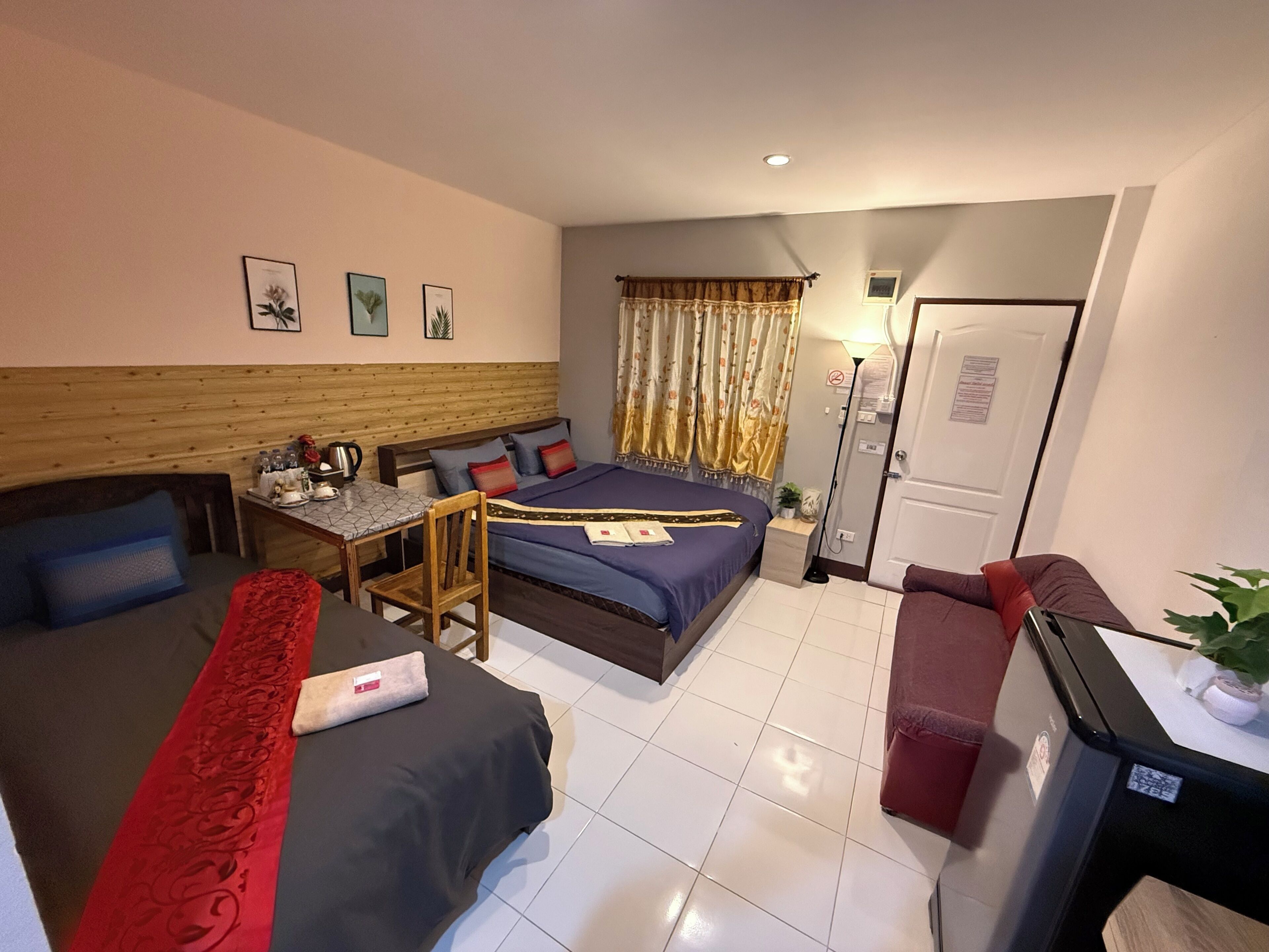 A compact hotel room with a bed, a desk, a chair, and a small table.