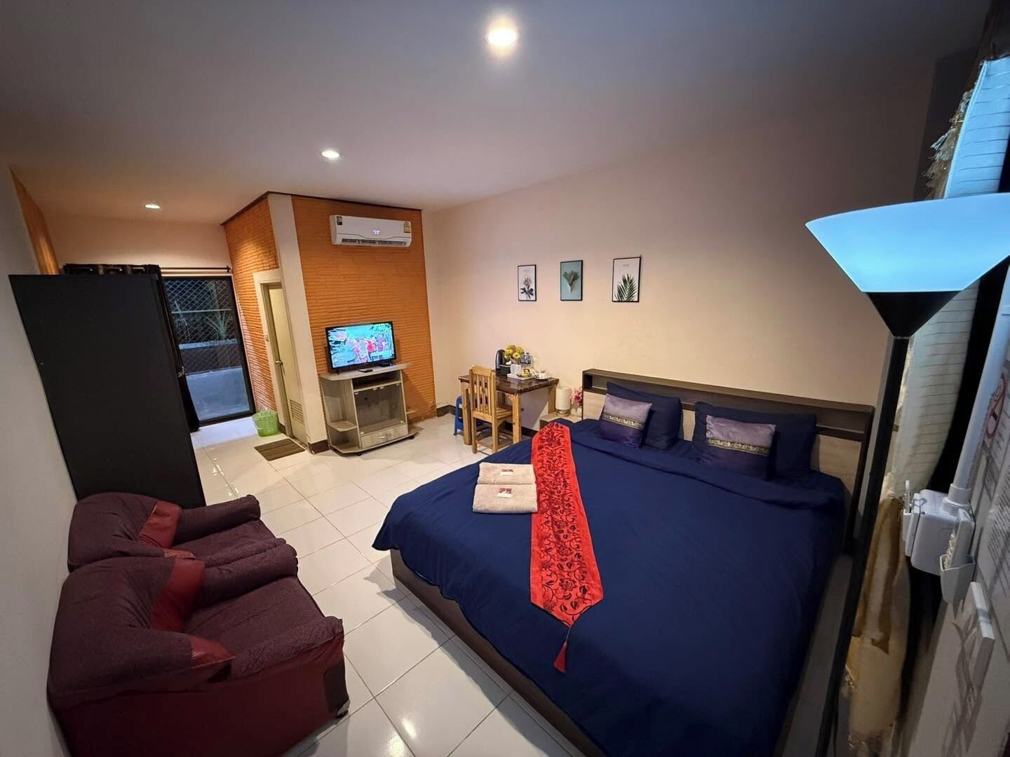 Une chambre d’hôtel avec un lit, une télévision, un bureau et une chaise.
