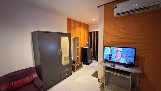 A modern living room with a television, a sofa, a wardrobe, and a speaker. - Sandee Place Mountain View Chomthong (Chom Thong)