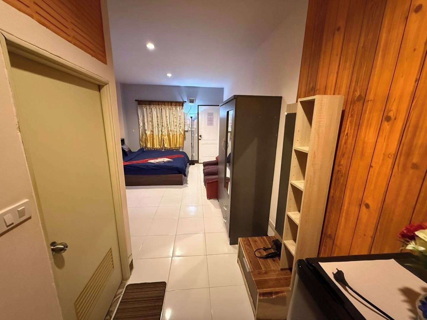 A hotel room with a bed, a desk, a wardrobe, and a bathroom.