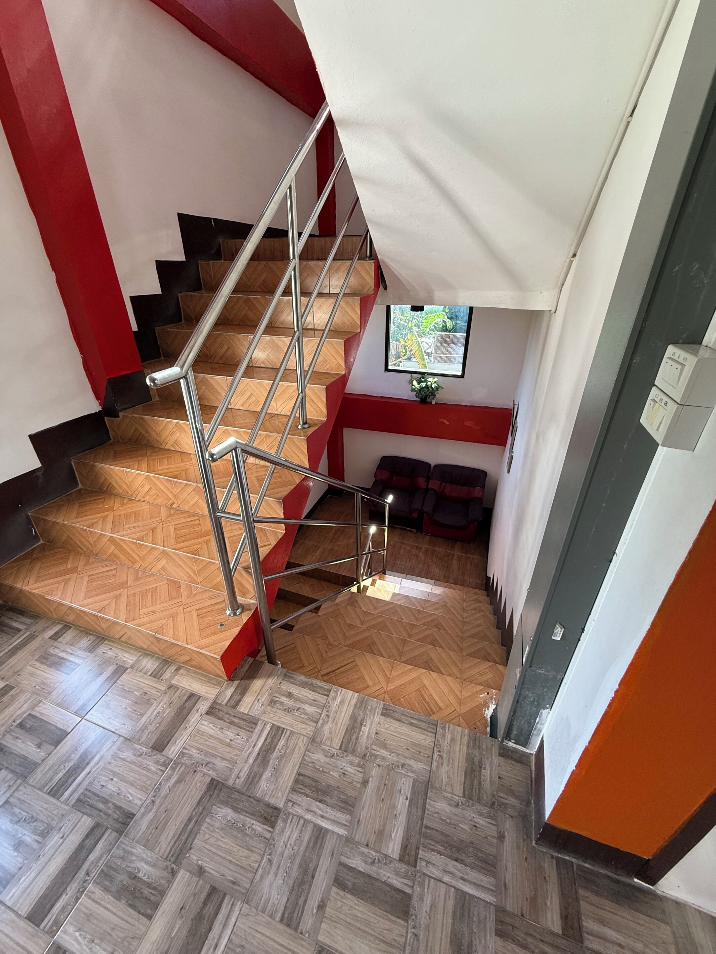 Una escalera con barandilla metálica que da a un rellano.