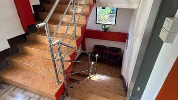 Una escalera con barandilla metálica que da a un rellano.