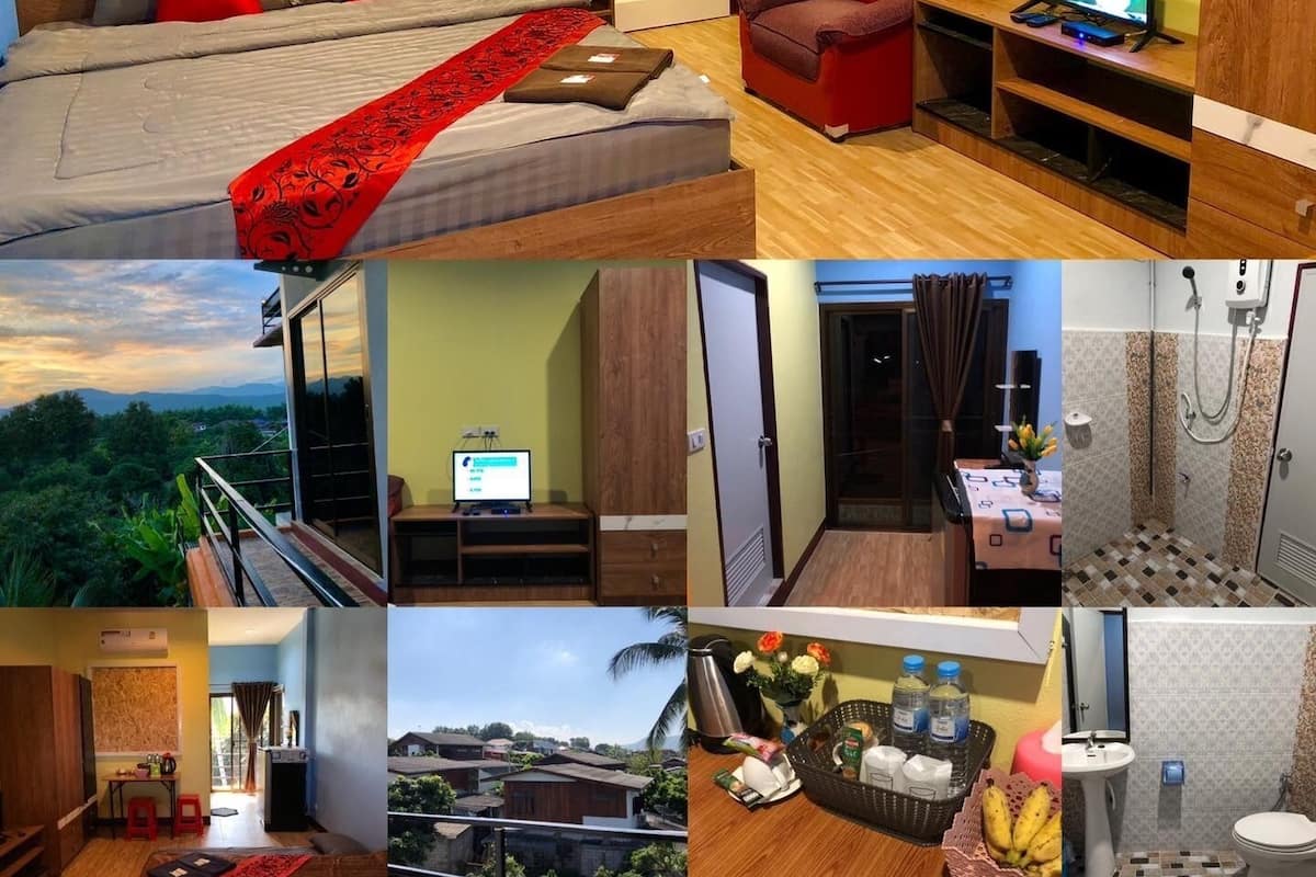 A bedroom with a bed, a red throw, and a TV in a corner.