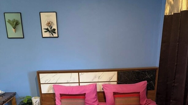 A neatly made bed with a red bedspread, two pink pillows, and a decorative headboard. - Sandee Place Mountain View Chomthong (Chom Thong)