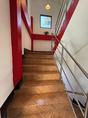 A staircase with wooden steps and metal railings, leading to a landing with a potted plant. - Sandee Place Mountain View Chomthong (Chom Thong)