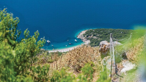 A coastal landscape with a clear view of the sea, a sandy beach, and a rocky outcrop with vegetation. - 1 bedroom nice home in Lubenice (Lubenice)