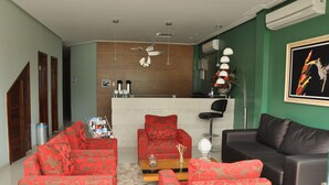 A living room with two sofas, a coffee table, and a bar area with a counter. - Beija Flor Hotel (Ipiau)