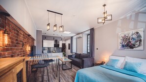 Eine moderne Wohnung mit Küche, Essbereich und einem Schlafzimmer mit großem Bett und blauer Bettwäsche.