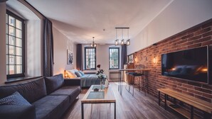 Ein modernes Wohnzimmer mit einer Couch, einem Couchtisch und einem an einer Ziegelwand befestigten Fernseher.