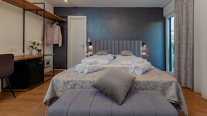 A modern bedroom with a bed, bedside tables, a desk, and a chair. - Seven Seas Residence (Split)