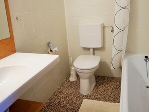 A bathroom with a white sink, toilet, and bathtub.