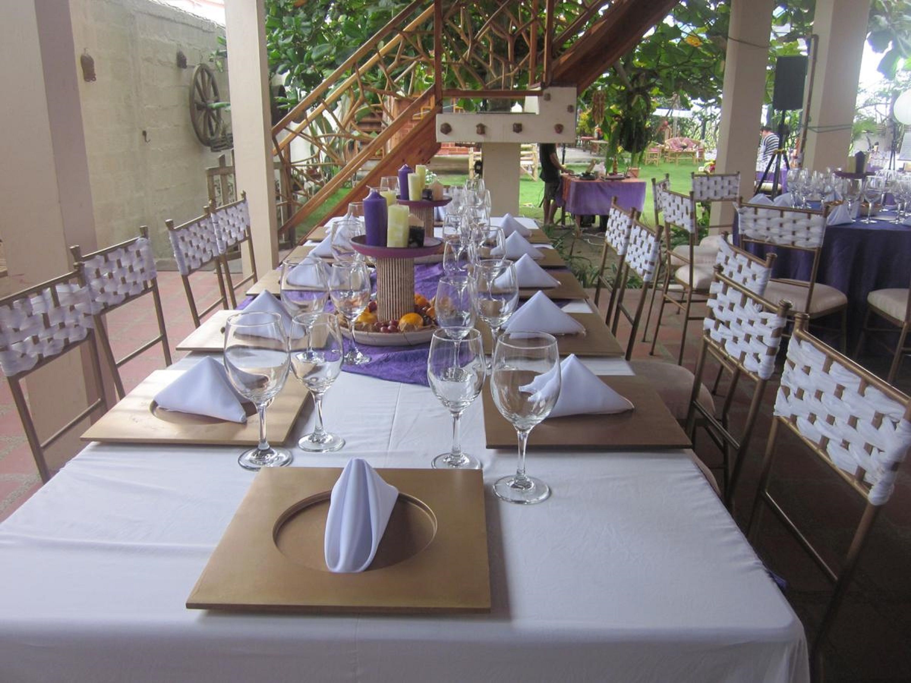 A long table set for a formal event with white napkins, wine glasses, and a centerpiece.