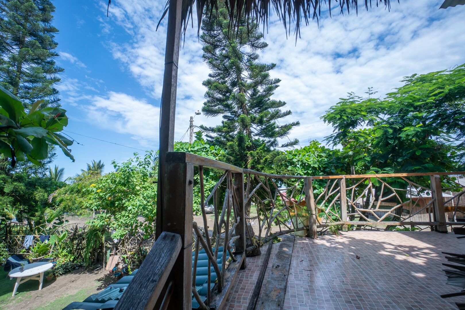 Un puente de madera en un jardín exuberante con cielo despejado.