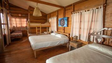 Una habitación acogedora de estilo cabaña con dos camas, una litera, paredes de madera, una lámpara colgante y un cuadro en la pared.
