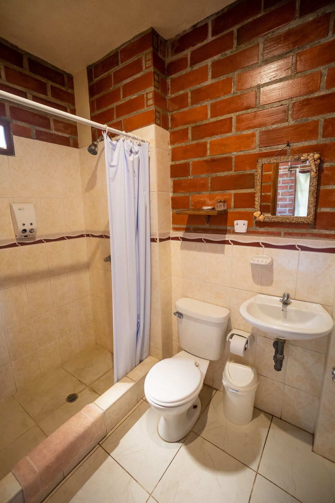 Ein Badezimmer mit Dusche, Toilette und Waschbecken.