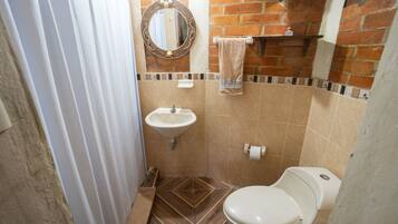 Un baño pequeño con lavamanos, inodoro y espejo.