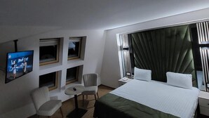 A hotel room with a large bed, a TV mounted on the wall, a desk, and a chair. - Wolf 2 (Zarnesti)