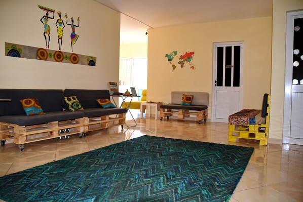 A living room with a sofa set, a coffee table, and a colorful rug.