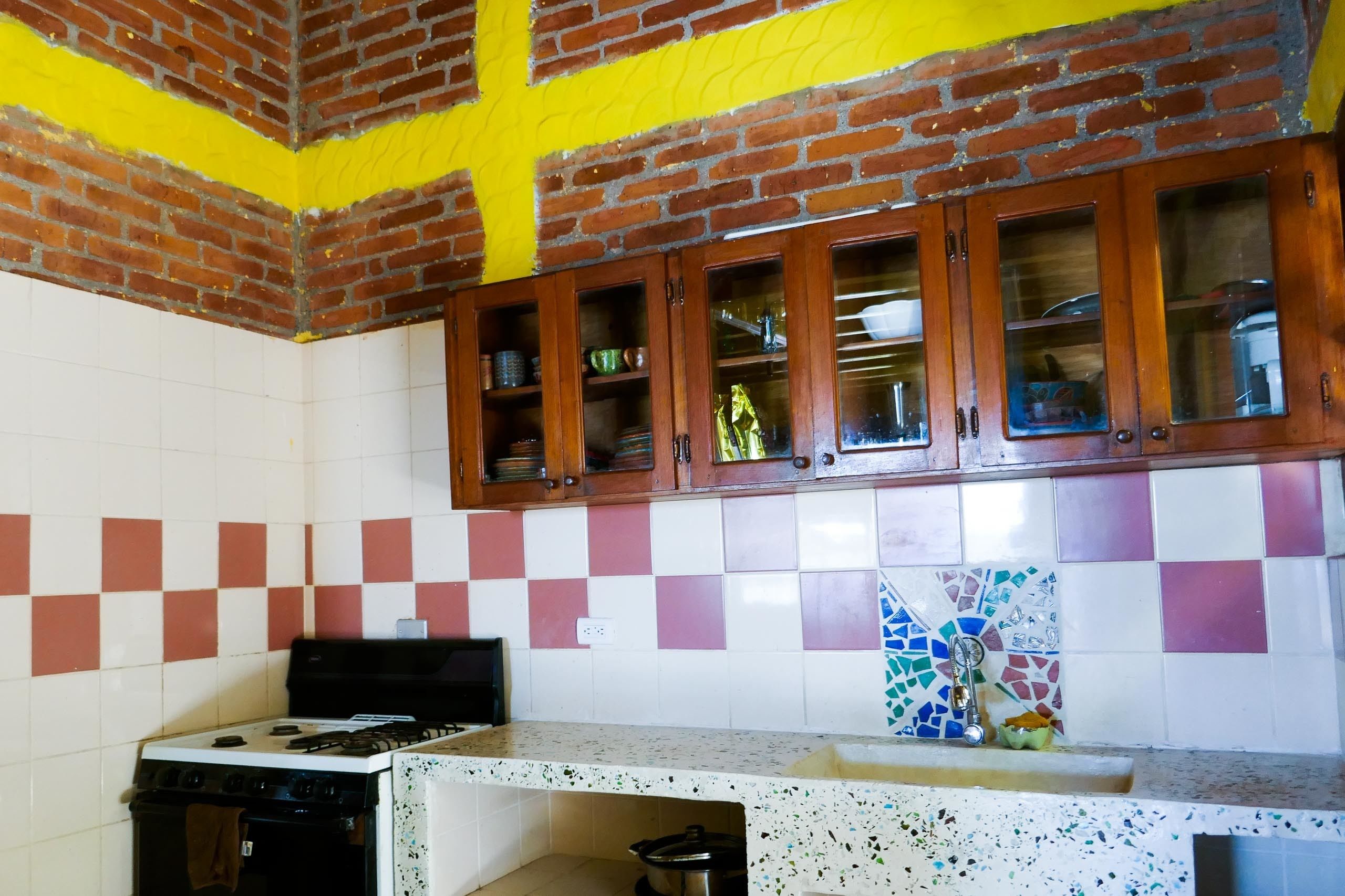 A kitchen with a gas stove, a sink, and wooden cabinets above.