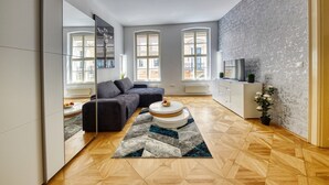 Una sala de estar moderna con un sofá, una mesa de centro y un televisor sobre un mueble.