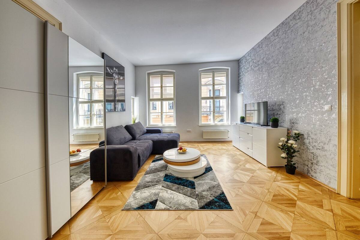 A modern living room with a sofa, a coffee table, and a TV on a cabinet.