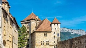 Un bâtiment historique en pierre, doté de plusieurs tours et d’une cour intérieure.