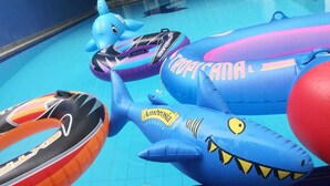 Una piscina interior con tiburones inflables y una zona de estar con sillones.