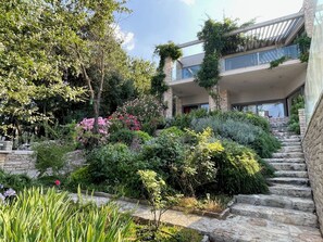 Stunning views from the second-floor balcony, surrounded by lush gardens and a stone staircase.