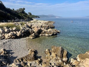 A rocky shoreline with clear water and distant mountains. - Contemporary villa on Istrian seaside (Drenje)