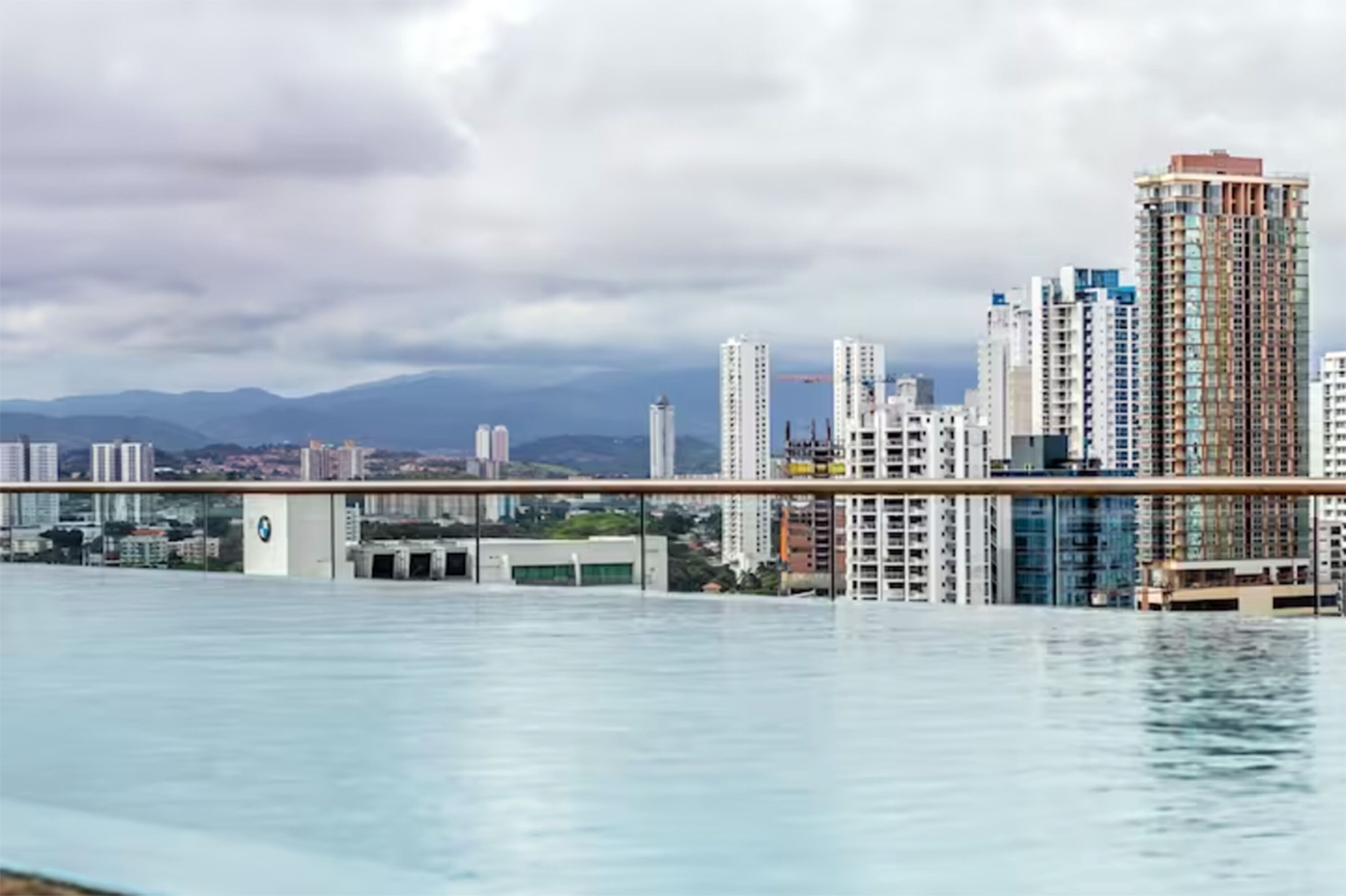 A cityscape with high-rise buildings and a bridge over water.