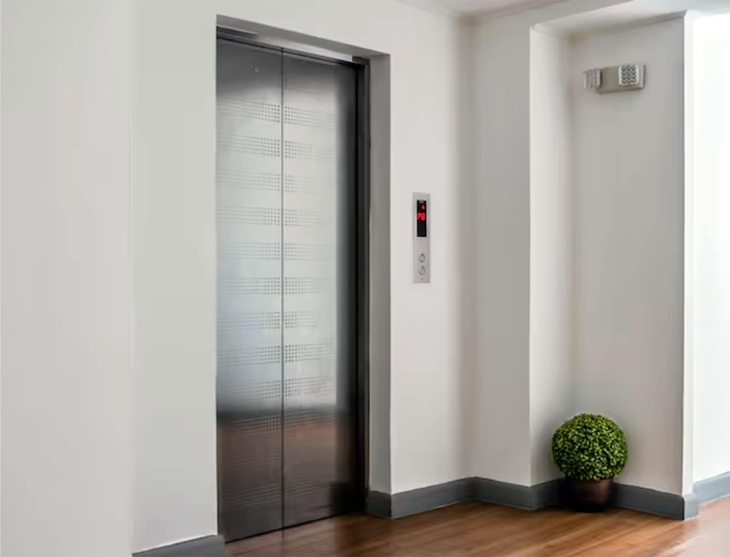 Un ascenseur moderne doté d’un écran numérique, d’une petite plante en pot et d’un intérieur épuré et minimaliste.