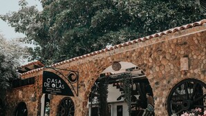 A stone building with a sign reading "CASA DE OLAS - Boutique Hotel - Puerto Escondido, Mexico."
