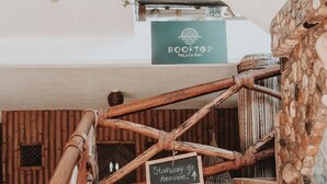 A wooden staircase with a sign reading "Stairway to heaven!" leading to a rooftop bar named Rooftop Palapa Bar.
