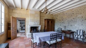 A dining area with a table set for six, a fireplace, stone walls, and a chandelier. - The Clos Jacquet house of 180 m2 (GUILLAC)