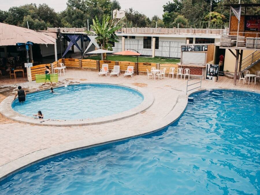 A pool area with a circular pool, lounge chairs, and a covered seating area.