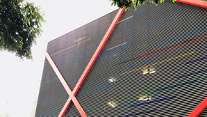 Um edifício moderno com um letreiro chamativo 'TIARA', fachada geométrica e um carro estacionado na frente.