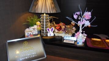 A hotel reception desk with a sign for 'Hotel Sweetets', a lamp, decorative items, and a small sign indicating 'Front'.