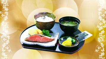 A tray with a bowl of soup, a bowl of rice, a piece of meat, and some vegetables.