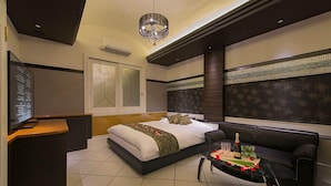 Une chambre d’hôtel moderne dotée d’un grand lit, d’un coin salon avec une table et d’un téléviseur.