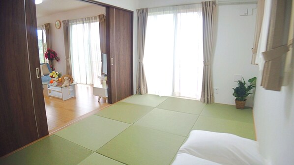 Una habitación con una cama, un sofá y una mesa de comedor.