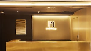 Un mostrador de recepción de diseño moderno, una cámara de seguridad y un cartel en la pared que muestra