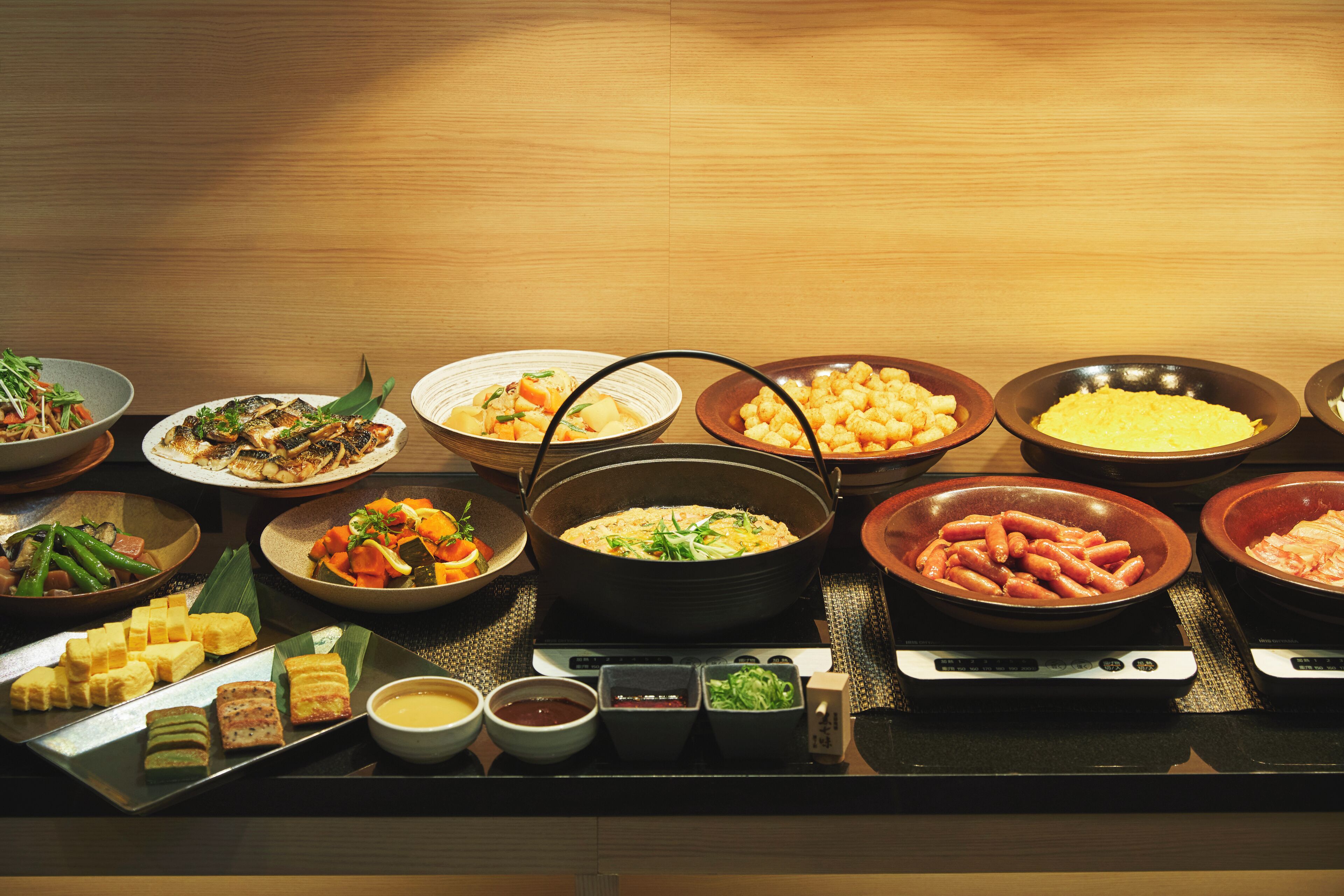 A buffet with various dishes and condiments.