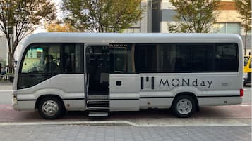 A white bus with the word "MONday" on its side parked on a paved area.